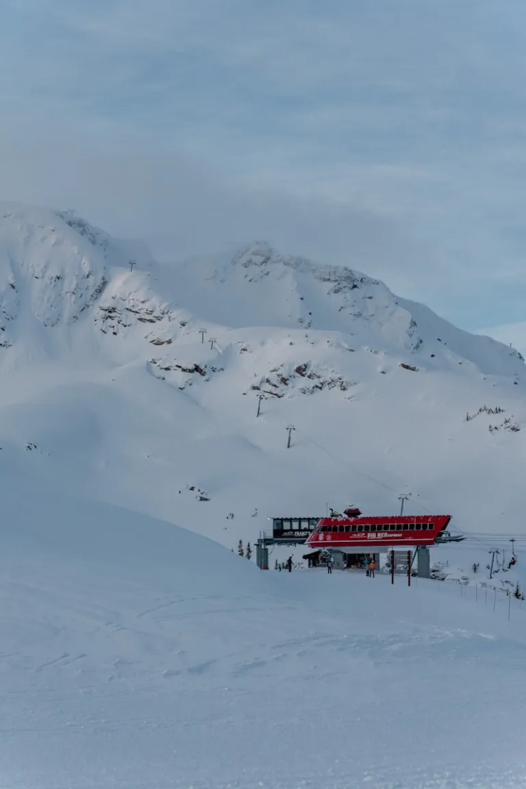 a red ski lift sitting on top of a snow covered slope